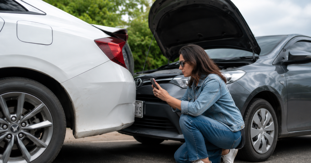 Woman documenting a rear-end car accident.