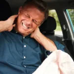 Driver experiencing whiplash pain after car accident